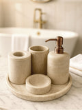 Luxury beige travertine marble bathroom accessory set displayed on a light stone countertop, featuring lotion dispenser, cotton jar, toothbrush holder, soap dish, tray, waste basket, and toilet brush — handcrafted Turkish travertine décor by Creative Home Designs.BAS-KRYKK-TRVTN-Cop-S7,BAS-KRYKK-TRVTN-Cop-S5