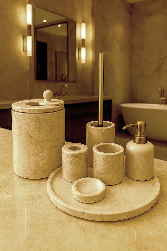 Luxury Toros beige gold marble bathroom accessory set with gold accents displayed on a dark marble countertop, featuring lotion dispenser, cotton jar, toothbrush holder, soap dish, tray, waste basket, and toilet brush — handcrafted Turkish marble décor by Creative Home Designs,BAS-KRYKK-TOROS-BEIGo-S5,BAS-KRYKK-TOROS-BEIGo-S7