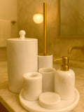 Luxury pearl white Afyon marble bathroom accessory set with gold accents displayed on a black marble countertop, featuring lotion dispenser, cotton box, toothbrush holder, soap dish, tray, waste basket, and toilet brush — handcrafted Turkish marble décor by Creative Home Designs,BAS-KRYKK-AFYON-PEARLGo-S7,BAS-KRYKK-AFYON-PEARLGo-S5