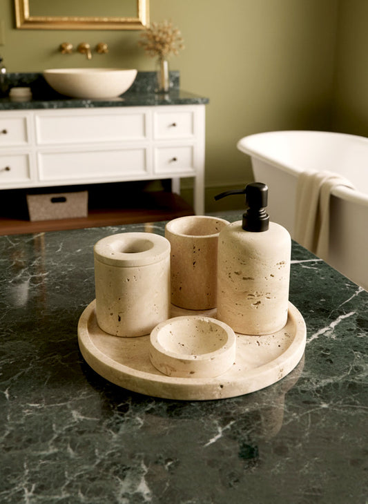 Luxury beige travertine marble bathroom accessory set displayed on a light stone countertop, featuring lotion dispenser, cotton jar, toothbrush holder, soap dish, tray, waste basket, and toilet brush — handcrafted Turkish travertine décor by Creative Home Designs.BAS-KRYKK-TRVTN-Bla-S7,BAS-KRYKK-TRVTN-Bla-S5