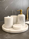 Luxury pearl white Afyon marble bathroom accessory set with gold accents displayed on a black marble countertop, featuring lotion dispenser, cotton box, toothbrush holder, soap dish, tray, waste basket, and toilet brush — handcrafted Turkish marble décor by Creative Home Designs,BAS-KRYKK-AFYON-PEARLGo-S7,BAS-KRYKK-AFYON-PEARLGo-S5