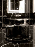 Luxury Toros black marble bathroom accessory set with silver accents displayed on a dark marble countertop, featuring lotion dispenser, cotton jar, toothbrush holder, soap dish, tray, waste basket, and toilet brush — handcrafted Turkish marble décor by Creative Home Designs,BAS-KRYKK-TOROS-BLASil-S7,BAS-KRYKK-TOROS-BLASil-S5