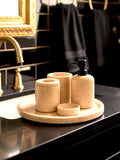Luxury Toros beige gold marble bathroom accessory set with gold accents displayed on a dark marble countertop, featuring lotion dispenser, cotton jar, toothbrush holder, soap dish, tray, waste basket, and toilet brush — handcrafted Turkish marble décor by Creative Home Designs,BAS-KRYKK-TOROS-BEIBla-S7,BAS-KRYKK-TOROS-BEIBla-S5