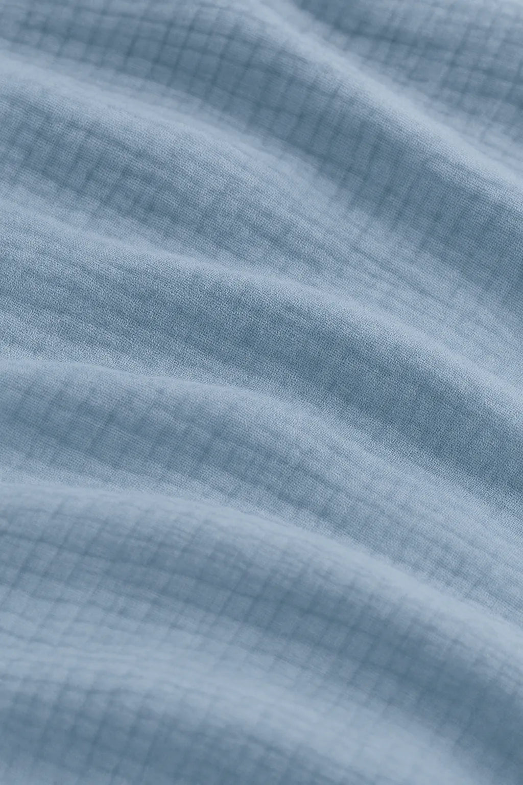 Luxury bedroom featuring a 100% muslin cotton Sky Blue gauze cloud blanket with matching pillows, styled on a bed beneath an arched window. BB-DesH-Blnkt-SkBlu-6070,BB-DesH-Blnkt-SkBlu-Tw,BB-DesH-Blnkt-SkBlu-Q,BB-DesH-Blnkt-SkBlu-K,BB-DesH-Blnkt-SkBlu-100118,BB-DesH-Blnkt-SkBlu-100125