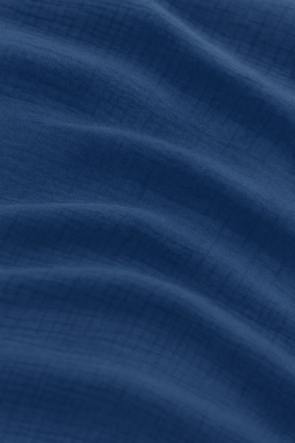 Luxury bedroom featuring a 100% muslin cotton Deep Blue gauze cloud blanket with matching pillows, styled on a bed beneath an arched window. BB-DesH-Blnkt-DeBlu-6070Price,BB-DesH-Blnkt-DeBlu-Tw,BB-DesH-Blnkt-DeBlu-Q,BB-DesH-Blnkt-DeBlu-K,BB-DesH-Blnkt-DeBlu-100118,BB-DesH-Blnkt-DeBlu-100125