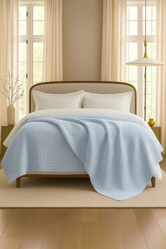 Bedroom with a neatly made bed styled with a 100% Turkish cotton waffle blanket, showing its textured waffle weave and cozy bedcover look as throw blanket by Creative Home. BB-DesH-WaBlnkt-SkBlu-6070,BB-DesH-WaBlnkt-SkBlu-Tw,BB-DesH-WaBlnkt-SkBlu-Q,BB-DesH-WaBlnkt-SkBlu-K,BB-DesH-WaBlnkt-SkBlu-100118,BB-DesH-WaBlnkt-SkBlu-100125