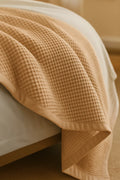 Bedroom with a neatly made bed styled with a 100% Turkish cotton waffle blanket, showing its textured waffle weave and cozy bedcover look as throw blanket by Creative Home.BB-DesH-WaBlnkt-Latte-6070,BB-DesH-WaBlnkt-Latte-Tw,BB-DesH-WaBlnkt-Latte-Q,BB-DesH-WaBlnkt-Latte-K,BB-DesH-WaBlnkt-Latte-100118,BB-DesH-WaBlnkt-Latte-100125
