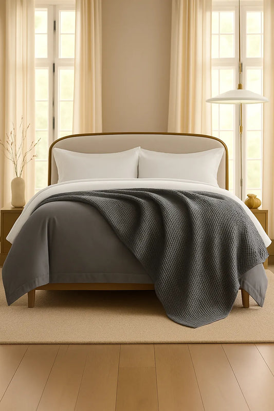 Bedroom with a neatly made bed styled with a 100% Turkish cotton waffle blanket, showing its textured waffle weave and cozy bedcover look as throw blanket by Creative Home. BB-DesH-WaBlnkt-Gra-6070,BB-DesH-WaBlnkt-Gra-Tw,BB-DesH-WaBlnkt-Gra-Q,BB-DesH-WaBlnkt-Gra-K,BB-DesH-WaBlnkt-Gra-100118,BB-DesH-WaBlnkt-Gra-100125