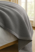 Bedroom with a neatly made bed styled with a 100% Turkish cotton waffle blanket, showing its textured waffle weave and cozy bedcover look as throw blanket by Creative Home. BB-DesH-WaBlnkt-Gra-6070,BB-DesH-WaBlnkt-Gra-Tw,BB-DesH-WaBlnkt-Gra-Q,BB-DesH-WaBlnkt-Gra-K,BB-DesH-WaBlnkt-Gra-100118,BB-DesH-WaBlnkt-Gra-100125