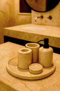 Luxury Toros beige gold marble bathroom accessory set with gold accents displayed on a dark marble countertop, featuring lotion dispenser, cotton jar, toothbrush holder, soap dish, tray, waste basket, and toilet brush — handcrafted Turkish marble décor by Creative Home Designs,BAS-KRYKK-TOROS-BEIBla-S7,BAS-KRYKK-TOROS-BEIBla-S5