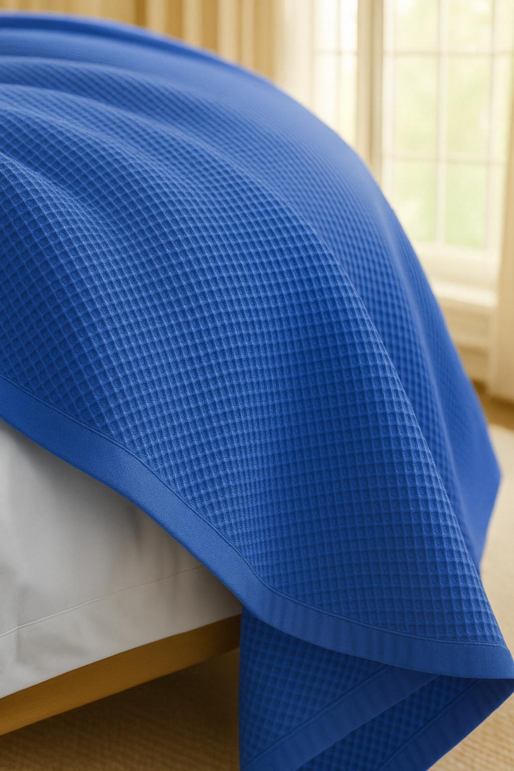 Bedroom with a neatly made bed styled with a 100% Turkish cotton waffle blanket, showing its textured waffle weave and cozy bedcover look as throw blanket by Creative Home.BB-DesH-WaBlnkt-DeBlu-6070,BB-DesH-WaBlnkt-DeBlu-Tw,BB-DesH-WaBlnkt-DeBlu-Q,BB-DesH-WaBlnkt-DeBlu-K,BB-DesH-WaBlnkt-DeBlu-100118,BB-DesH-WaBlnkt-DeBlu-100125