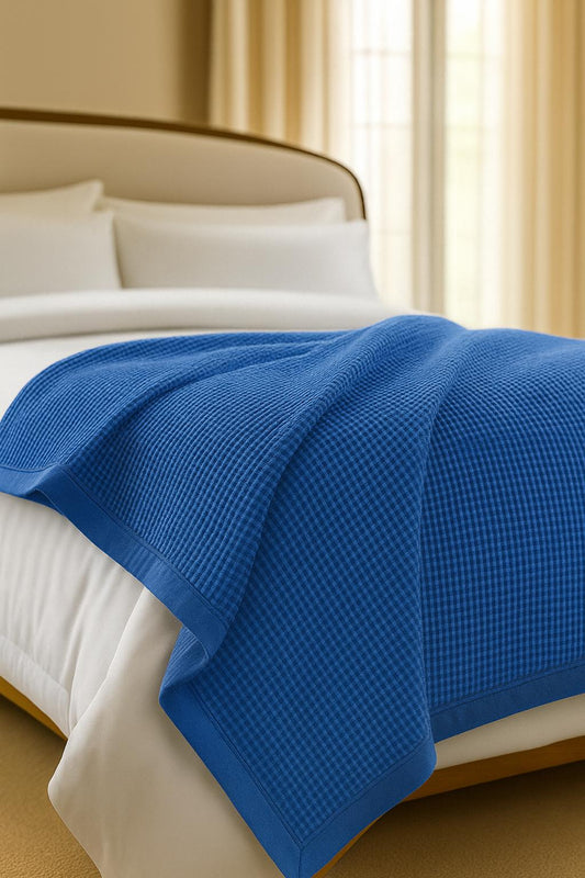 Bedroom with a neatly made bed styled with a 100% Turkish cotton waffle blanket, showing its textured waffle weave and cozy bedcover look as throw blanket by Creative Home.BB-DesH-WaBlnkt-DeBlu-6070,BB-DesH-WaBlnkt-DeBlu-Tw,BB-DesH-WaBlnkt-DeBlu-Q,BB-DesH-WaBlnkt-DeBlu-K,BB-DesH-WaBlnkt-DeBlu-100118,BB-DesH-WaBlnkt-DeBlu-100125